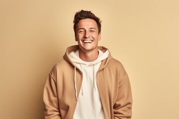 Wall Mural - Environmental portrait photography of a happy boy in his 30s wearing a stylish hoodie against a beige background. With generative AI technology