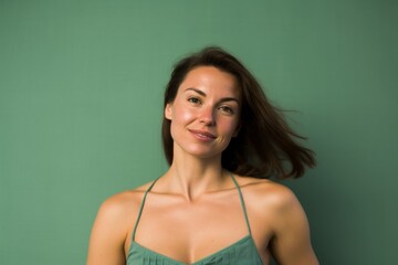 Canvas Print - Lifestyle portrait photography of a glad girl in her 30s wearing a daring tube top against a spearmint green background. With generative AI technology