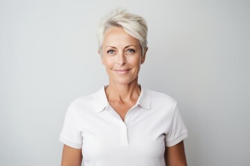 Wall Mural - Lifestyle portrait photography of a glad mature woman wearing a sporty polo shirt against a minimalist or empty room background. With generative AI technology