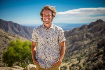 Wall Mural - Eclectic portrait photography of a satisfied boy in his 30s wearing a casual short-sleeve shirt against a mountain range background. With generative AI technology