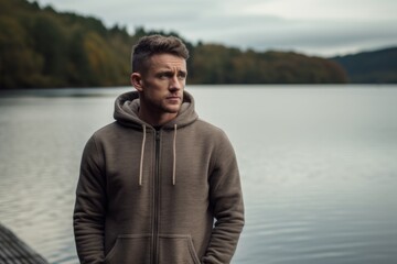 Wall Mural - Sports portrait photography of a tender boy in his 30s wearing a stylish hoodie against a tranquil lake background. With generative AI technology