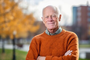 Wall Mural - Studio portrait photography of a grinning old man wearing a cozy sweater against a vibrant city park background. With generative AI technology