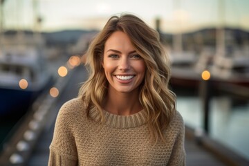 Wall Mural - Close-up portrait photography of a joyful girl in her 30s wearing a cozy sweater against a busy marina background. With generative AI technology