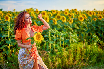 portrait of a beautiful woman near a field of sunflowers on a sunny day at sunset.