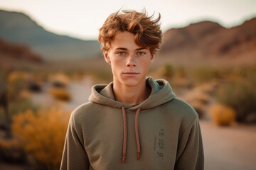 Wall Mural - Environmental portrait photography of a glad mature boy wearing a stylish hoodie against a picturesque desert oasis background. With generative AI technology