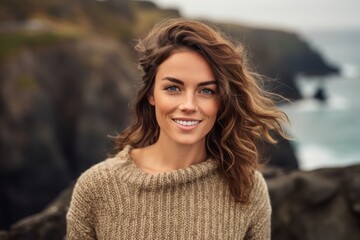 Wall Mural - Headshot portrait photography of a satisfied girl in her 30s wearing a cozy sweater against a scenic cliffside village background. With generative AI technology