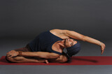 Fototapeta  - Man doing yoga in photo studio on isolated grey background.