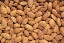 Pile Of Almond Seeds Close-up As Background. Pile Of Apricot Kernel Peeled. Healthy Eating Diet, Nutrition, Vegan Concept. Protein Organic Food. Dry Snack. National Nut Day. Copy Space For Text