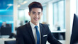 Asian male with a happy smile on his face, wearing a formal black suit, working in an office background
