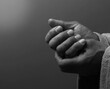 © herlanzer - man praying to god with hands together on grey black background stock image stock photo
