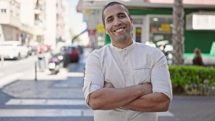 Canvas Print - Young hispanic man standing with crossed arms at street