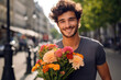 Happy young man holding a flower bouquet in his hands, going to a romantic date in Paris