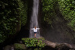 © Julija - Waterfall in tropical jungle and alone woman tourist. Leke Leke waterfall in Bali, Indonesia.