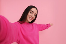 Smiling Young Woman Taking Selfie On Pink Background, Space For Text