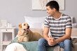 © Pixel-Shot - Young man with Labrador dog in bedroom