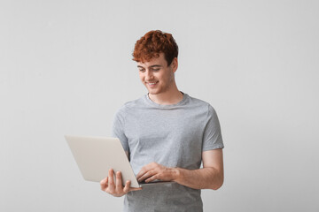 Poster - Male programmer working with laptop on light background