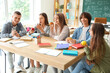 © Pixel-Shot - Group of teenage students having snacks at table in classroom