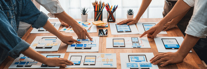 Wall Mural - panorama shot of front-end developer team brainstorming ui and ux designs for mobile app on paper wi