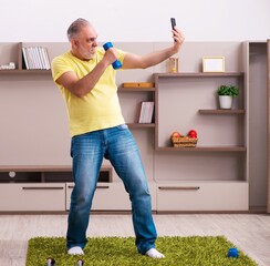 Wall Mural - Aged man doing sport exercises at home