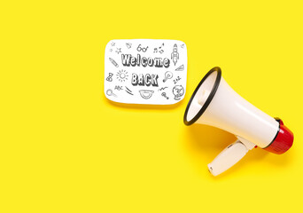 Megaphone and sheet with text WELCOME BACK on yellow background