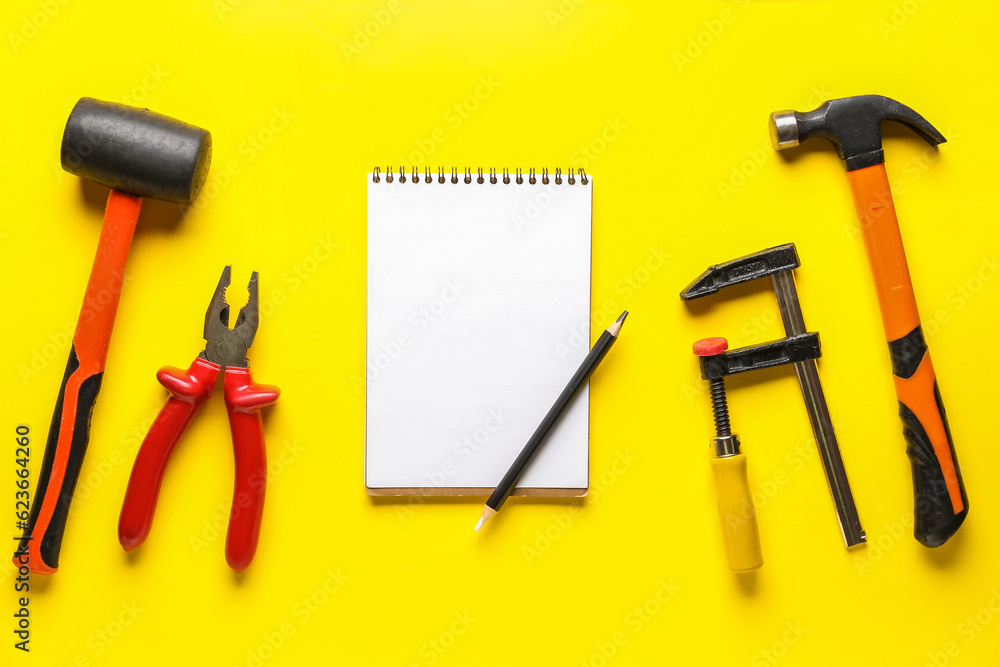 Composition with different tools, notebook and pencil on yellow background. Labor Day celebration