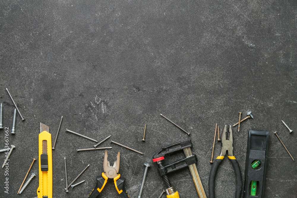 Different tools, nails and screws on black grunge background. Labor Day celebration