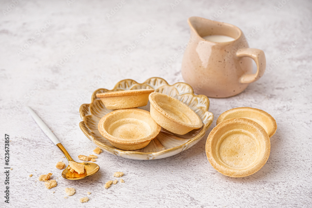 Plate with homemade tartlets on white background
