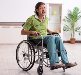 Wall Mural - Young male invalid in wheel-chair suffering at home