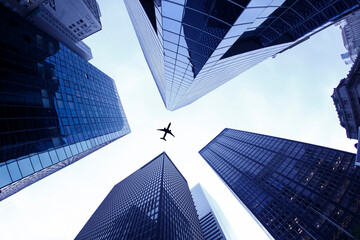 Airplane flies over skyscrapers. Flying passenger jet plane from below. Airplane flying on business skyscrapers of financial center Wall street district in New York City 2024