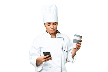 Wall Mural - Young woman Chef over isolated chroma key background holding coffee to take away and a mobile