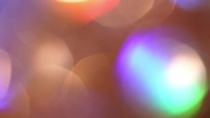 Wall Mural - Gold Bokeh Shimmers with colorful tints shades. Blurred bokeh lights particles abstract motion background. Defocused shiny sparkling circles as a Christmas symbols.