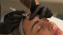 Beauty Clinic. Beautician Hands In Gloves Making Face Aging Injection In A Female Skin. A Woman Gets Beauty Facial Cosmetology Procedure. Botox. Collagen Injections. Shot In 4k