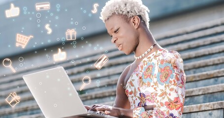 Black transgender person using laptop on stairs