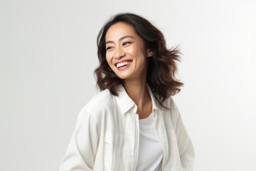 Wall Mural - Portrait of a happy young asian woman smiling against white background