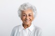 Portrait of smiling senior woman looking at camera on white background.