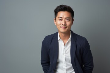 Wall Mural - Portrait of young asian business man isolated on gray background.