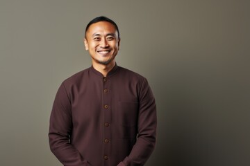 Wall Mural - Portrait of a smiling young asian man wearing a brown shirt