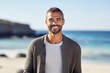 © Robert MEYNER - Portrait of a smiling young man standing on the beach at the day time