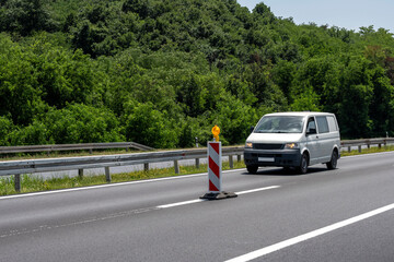 Wall Mural - White modern delivery small shipment cargo courier van moving fast on motorway road to city urban suburb.	