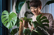 © leszekglasner - Woman among plants in her home jungle