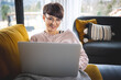 © leszekglasner - Smiling woman doing video call using laptop at home