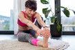 © leszekglasner - Smiling sporty woman stretching after workout exercises at home floor