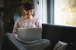 © leszekglasner - Smiling woman doing video call using laptop at home