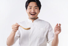 A Middle-aged Man In A Chef's Suit Holds A Spoon