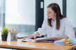 © Tj - Portrait of beautiful smiling young brunette businesswoman sitting at in the office modern work station