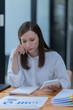 © Tj - Portrait of beautiful smiling young brunette businesswoman sitting at in the office modern work station