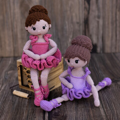 Wall Mural - Cute Knitted ballerina doll – amigurumi toy. Handmade doll siting on wooden background	