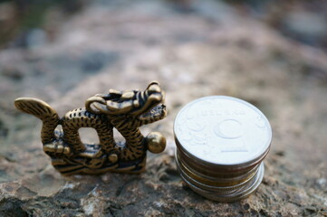 Wall Mural - A Chinese dragon figurine and a stack of coins.