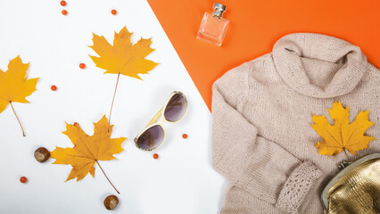 Wall Mural - Top view photo of autumn composition sweater maple leaves on isolated white and orange background