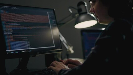 A young girl programmer in the IT sphere writes code while in her home office working remotely online from her laptop computer. Girl programmer web designer writes code, looks at the computer monitor
